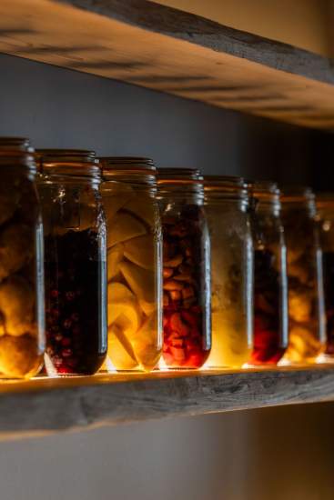 Bocaux de légumes en fermentation alignés sur une étagère du restaurant gastronomique Køkken à Strasbourg