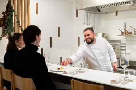 Chef du restaurant gastronomique Køkken à Strasbourg servant un plat à un client au comptoir