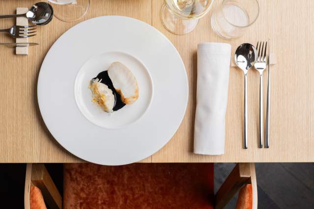Plat gastronomique dressé en assiette blanche sur une table de restaurant du restaurant Køkken à Strasbourg