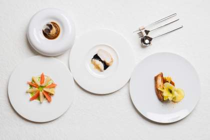 Sélection de plats gastronomiques dressés en assiettes blanches sur une table dans le restaurant Køkken à Strasbourg