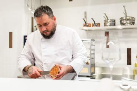 Chef du restaurant Køkken à Strasbourg préparant un plat en cuisine