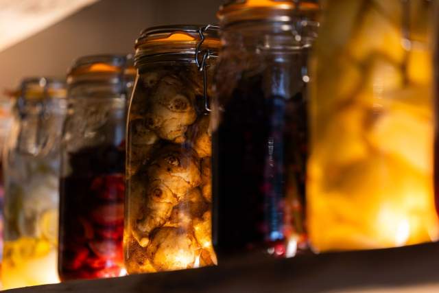 Bocaux de légumes en fermentation sur une étagère en cuisine du restaurant Køkken à Strasbourg